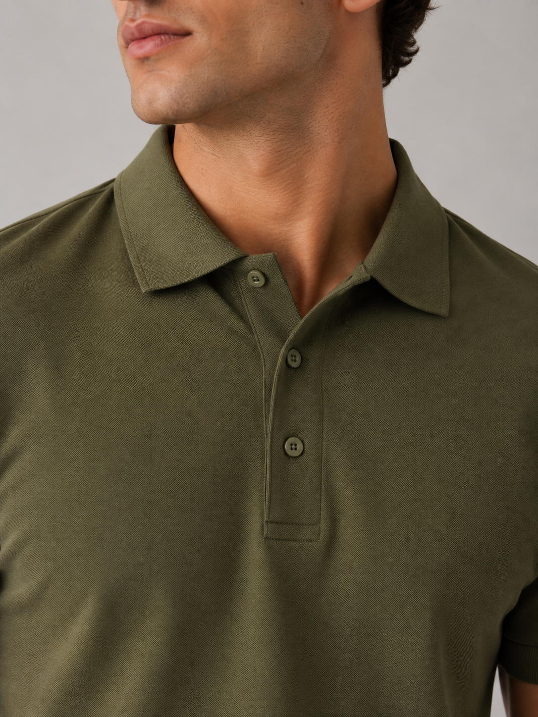 Men's olive green polo shirt, back view showing clean shoulder construction and tailored drape